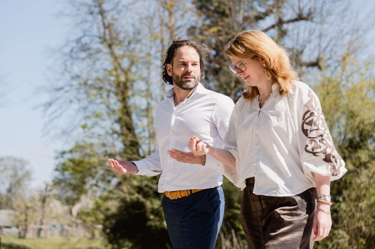 Twee leiders in gesprek tijdens een wandeling door de natuur bij De School voor Transitie over leiderschap, verbinding en persoonlijke groei.
