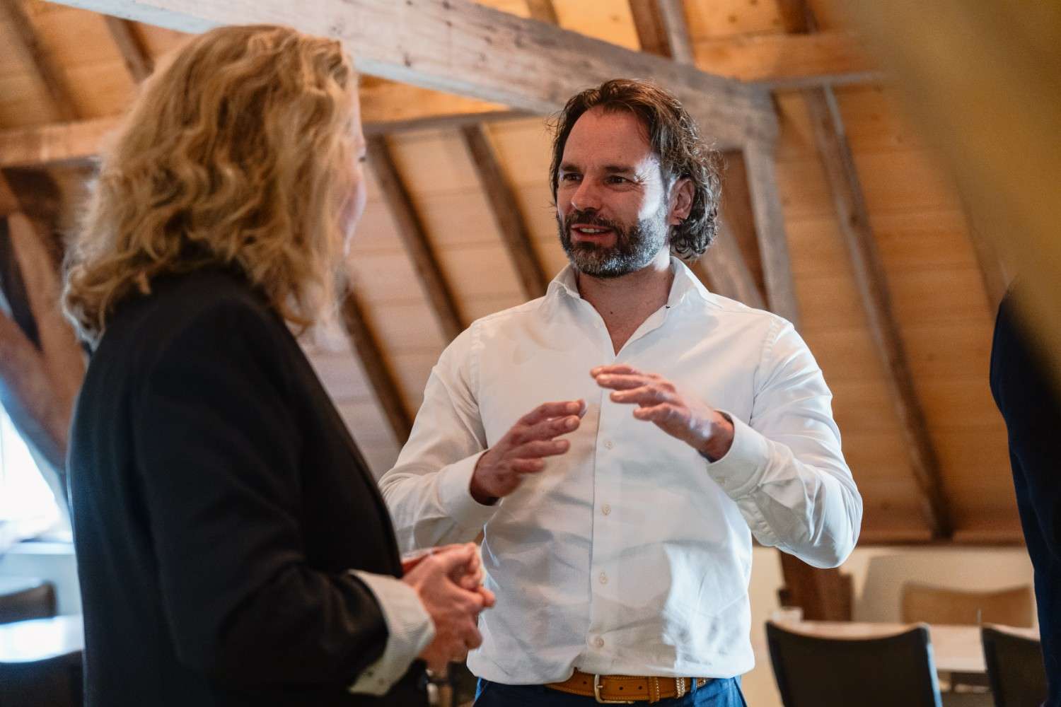 Trainer en deelnemer in gesprek tijdens een leiderschapstraining van De School voor Transitie over verbinding, vertrouwen en verandering.