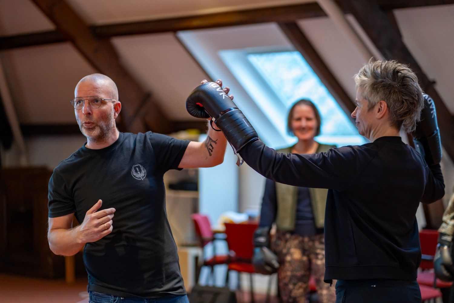 Trainer geeft bokscoaching tijdens leiderschapstraining van De School voor Transitie over persoonlijk leiderschap en veerkracht.
